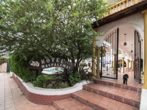 a sign for a store in a building with a tree at Hotel Maspalomas in Villa Carlos Paz