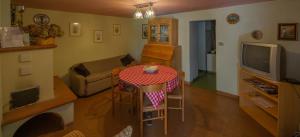 ein Wohnzimmer mit einem Tisch und einem TV in der Unterkunft Casa Fiorellino in Belluno