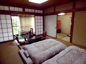 Postel nebo postele na pokoji v ubytování Oshi Ryokan