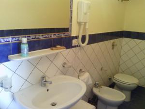 a bathroom with a sink and a toilet and a phone at Oasi Di Casablanca in Lampedusa
