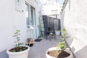 einen Balkon mit Topfpflanzen sowie einem Tisch und Stühlen in der Unterkunft Apartman Zagreb Maksimir in Zagreb