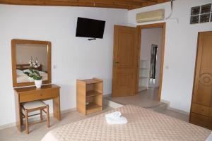 a bedroom with a bed and a desk and a mirror at Eftihia Studios in Kavos