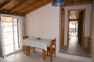 a dining room with a table and chairs and a balcony at Eftihia Studios in Kavos
