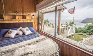 1 dormitorio con cama y ventana grande en Hostería La Casa del Mar, en Bahía Mansa