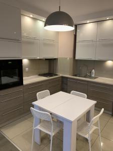 a kitchen with a white table and chairs at Apartament Ryska 3A in Białystok