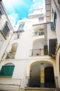 - un grand bâtiment blanc avec balcon et fenêtres dans l'établissement LegnoSuites, à Naples
