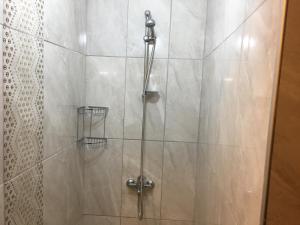 a shower stall with a glass door with a shower at Adali Guest House in Bozcaada