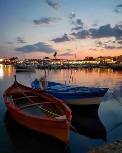 Due barche sono ormeggiate in un porto al tramonto di Appartamento aria di Mare a Marzamemi