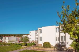 an image of a white apartment building at Hotel Omorika in Punat