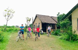 a group of people on bikes in front of a house at May Homestay - Tam Coc Local Village in Ninh Binh