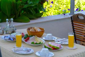 a table with plates of food and glasses of orange juice at B&B Garni Stefi! in Supetarska Draga