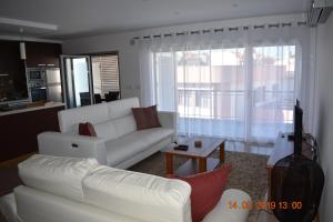 een woonkamer met een witte bank en een tafel bij Quarportugal in São Martinho do Porto