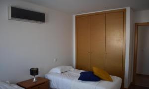 een slaapkamer met een bed en een houten kast bij Quarportugal in São Martinho do Porto