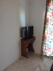 een televisie op een houten tafel in een kamer bij Fania Apartments in Kardamaina