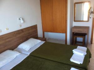 a bedroom with a bed with two towels on it at Fania Apartments in Kardamaina