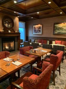 a restaurant with wooden tables and chairs and a fireplace at Inn By the Sea in Cape Elizabeth