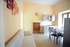 a living room with a couch and a table in a kitchen at La Mela Rosa in Valentano