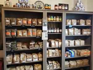 a shelf full of breads and other food items at Tinyhouse NATUURHUISJE met veranda Bij de Molen tussen Alkmaar en Hoorn in Oterleek