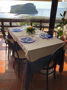 einen Tisch mit Stühlen und Meerblick in der Unterkunft Hotel Normanni in Praia a Mare