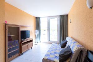 Televízia a/alebo spoločenská miestnosť v ubytovaní Sistach Rentals Apartaments Sol 304 & 404