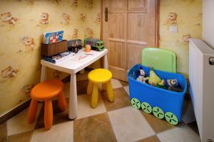 una sala de juguetes con una mesa y dos taburetes en Sasvár Apartman en Eger