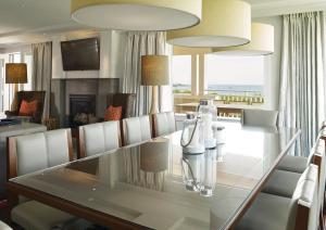 a dining room with a glass table and chairs at Inn By the Sea in Cape Elizabeth