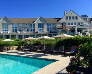 a resort with a swimming pool with chairs and umbrellas at Inn By the Sea in Cape Elizabeth