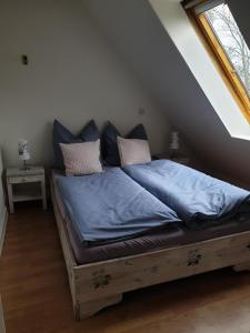 a bed with blue sheets and pillows in a room at Schoppstuv in Tümlauer Koog