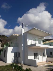 Alexia's house في Chortáta: منزل أبيض مع شرفة فوقه