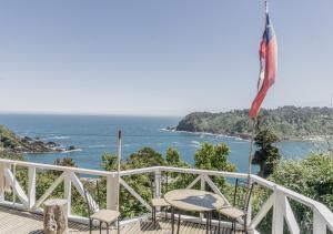a deck with chairs and an american flag and the ocean at Hostería La Casa del Mar in Bahía Mansa