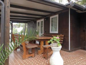 a patio with a wooden table and a vase with flowers at cucaracha in Catania