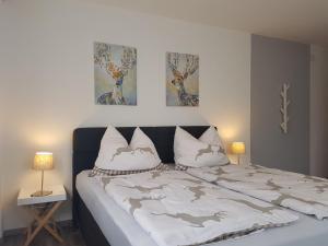 - une chambre avec un lit et 2 photos sur le mur dans l'établissement Appartementhaus Zraunig, à Flattach