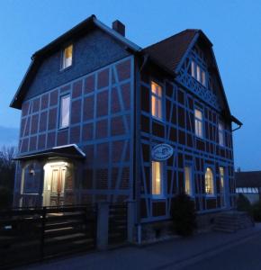 a large blue building with its lights on at alte Apotheke in Roßdorf