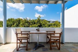 a table and chairs on a balcony with a view at Iliopoulou Studios in Pollonia