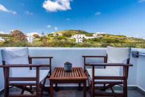 two chairs and a table on a balcony at Iliopoulou Studios in Pollonia