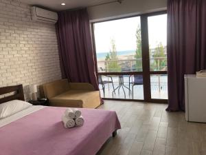 a hotel room with a bed and a balcony at Золотий ЛЕВ in Zatoka