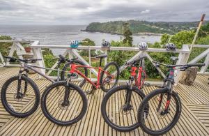 a group of three bikes parked next to a rail at Hostería La Casa del Mar in Bahía Mansa