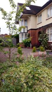 a house with a lot of plants in front of it at Kingsway Bed & Breakfast in Broxbourne