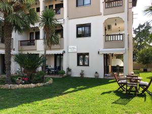 a building with a table and chairs in a yard at kassandrinos apartments apostolos in Nikiti