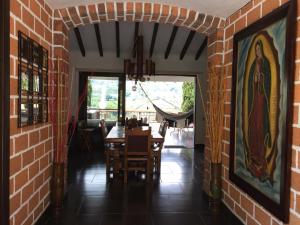 une salle à manger avec une table et un mur en briques dans l'établissement CASA CAMPESTRE MONTECARLO Guatapé- desayuno a pareja, à Guatapé