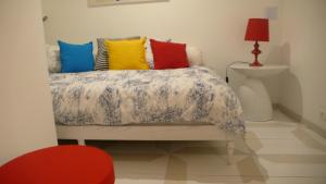 una camera da letto con un letto con cuscini colorati di Oliveirinha a Lisbona