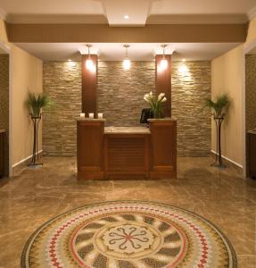 a lobby with a reception desk and a clock on the floor at Inn By the Sea in Cape Elizabeth