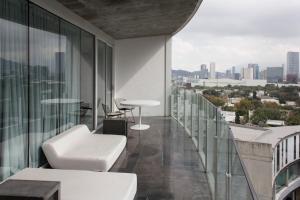 a balcony with white furniture and a view of the city at Habita Monterrey, a Member of Design Hotels in Monterrey