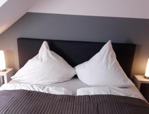 uma cama com almofadas brancas em cima em Ferienwohnung mit 2 Schlafzimmern und Parkplatz em Erfurt