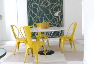 リスボンにあるオリビーニエの黄色い椅子とカボチャが置かれたテーブル