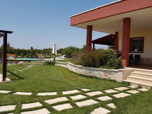 a house with a patio and a grass yard at M&A Relax in Martina Franca