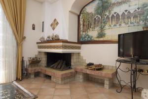 a living room with a fireplace and a flat screen tv at Panorama Host - Domus Amalfi Coast in Maiori