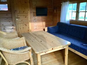 a living room with a wooden table and a couch at Harran Camping in Grong