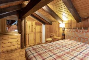 布呂松的住宿－La baita di Brusson，一间卧室设有床铺、木墙和木地板