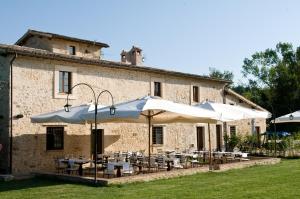 a group of tables and umbrellas in front of a building at Locanda Rovicciano in Castel Ritaldi